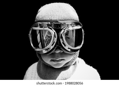 Portrait of an Asian boy pilot in vintage aviator helmet and goggles. Black and white vintage photograph.