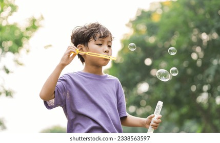 portrait of asian boy playing blowing bubbles - Powered by Shutterstock