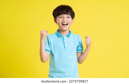 portrait an asian boy posing yellow background