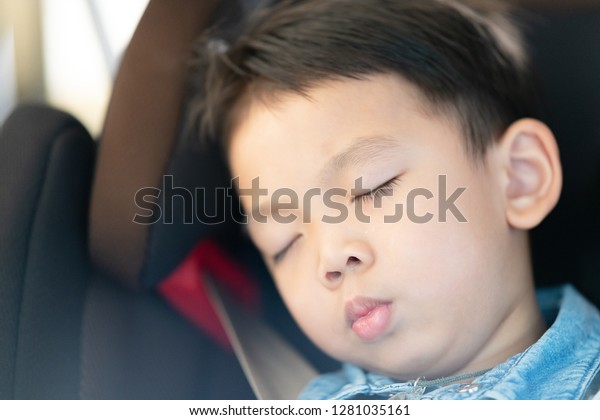 Portrait of asian
boy wearing jean shirt sleeping in car seat, image with toning and
effect of soft shining
sun