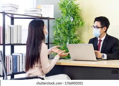 Portrait Of Asian Business Advisor Giving Advice To Customer About Financial Loan Situation In Bank Office. New Normal Social Distance Business For Banking Financial And Investment Concept.