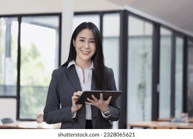 Portrait of asian business woman holding a digital tablet and standing in creative office, Successful businesswoman.
