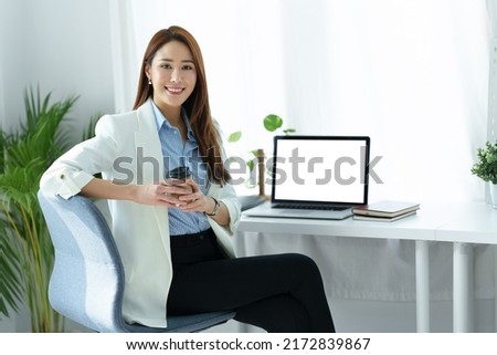 Portrait of an Asian business woman sitting at work and using a computer labtop in the office.