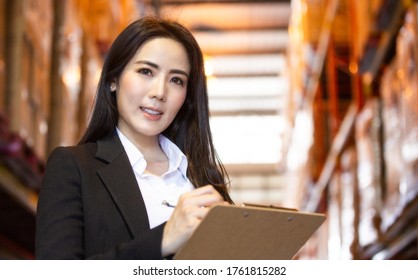 Portrait Of Asian Business Woman Or Vice President Smiling And Holding Clipboard At Warehouse Factory. Confidence People With Positive Vision Working At Import Export Company Concept With Copy Space