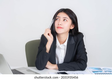 Portrait Of Asian Business Young Woman Company Employee Working In Front Of A Laptop Computer On Office Desk , Thinking About How To Make Money Online From The Money- Lifestyle Business People Concept