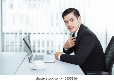 Portrait Of Asian Businessman Sitting At His Workplace