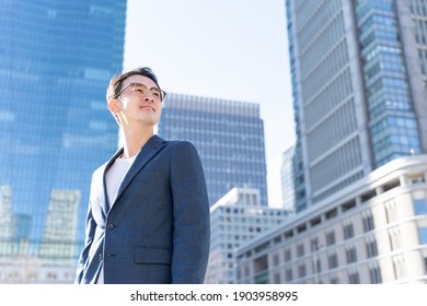 portrait of asian businessman standing in front of building