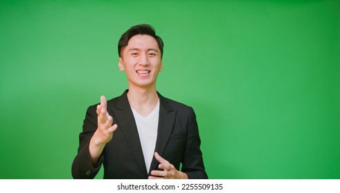  portrait asian businessman wear black suit hosting tv show or advertisement in front of green screen - Powered by Shutterstock