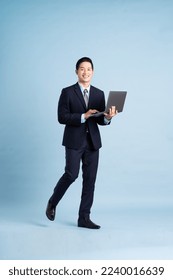 portrait of asian businessman wearing suit on blue background - Shutterstock ID 2240016639