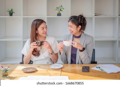 Portrait Of Asian Businesswoman Drinks Coffee With College Happily,  Coffee And Chatting At Break Time