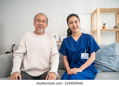 Portrait Of Asian Caregiver Nurse Sit On Sofa And Take Care Senior Man. Attractive Specialist Carer Women Support Older Elderly Mature Grandfather At Nursing Home Care And Smiling, Looking At Camera.