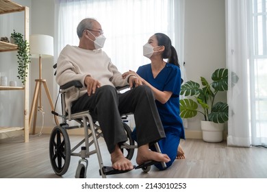 Portrait Of Asian Caregiver Nurse Take Care Senior Male On Wheelchair. Attractive Specialist Carer Women Wear Face Mask, Support Elderly Grandfather At Nursing Home Care And Smile, Look At Each Other.