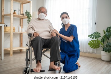 Portrait Of Asian Caregiver Nurse Take Care Senior Male On Wheelchair. Attractive Specialist Carer Women Wear Face Mask, Support Elderly Grandfather At Nursing Home Care And Smile, Look At Each Other.