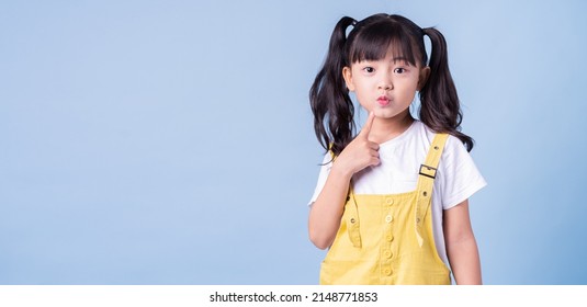 Portrait Of Asian Child Posing On Blue Background