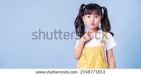Portrait of Asian child posing on blue background