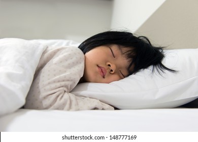 Portrait Of Asian Child Sleeping On The Bed