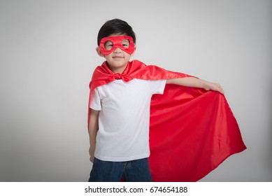 Portrait of Asian child in Superhero's costume on gray background - Powered by Shutterstock