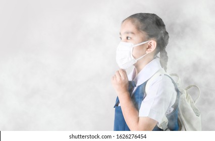 Portrait Asian Children Girl Wear  Mask To Protect PM 2.5 Dust And Air Pollution. Portrait Of Thai Student Wearing Protection Mask  Bad Weather, Pm2.5 Concept Background