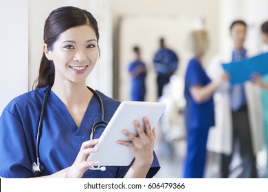 Portrait Asian Chinese Female Surgical Nursing Staff Wearing Scrubs With Medical Team In Hospital Using Touch Screen Tablet