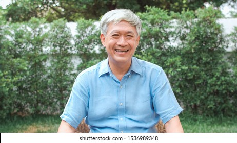 Portrait Asian Chinese Senior Man Feeling Happy Smiling At Home. Older Male Relax Toothy Smile Looking To Camera While Lying In The Garden At Home In The Morning Concept.