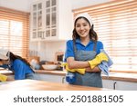 Portrait of Asian cleaning service woman worker working in the kitchen. Beautiful girl housewife housekeeper cleaner feel happy and relax, enjoy housekeeping housework or chores then looking at camera