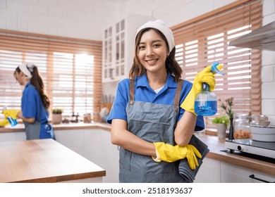 Portrait of Asian cleaning service woman worker working in the kitchen. Beautiful girl housewife housekeeper cleaner feel happy and relax, enjoy housekeeping housework or chores then looking at camera