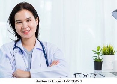 Portrait Asian Confident Female Doctor Working Personal Laptop Computer At The Hospital Office. Thai Woman Medical Expertise Staff Smiling Her Sitting Crossed Arm On Desk Space Front Computer