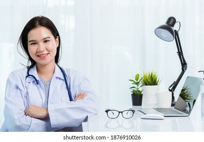 Portrait Asian Confident Female Doctor Working Personal Laptop Computer At The Hospital Office. Thai Woman Medical Expertise Staff Smiling Her Sitting Crossed Arm On Desk Space Front Computer