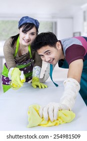 Portrait Of Asian Couple Cleaning A Table With Spring Cleaning Tools At Home