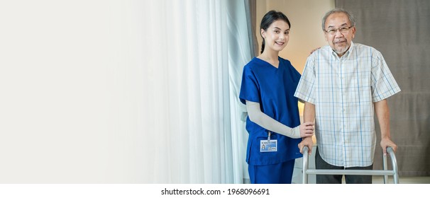 Portrait Of Asian Disabled Senior Elderly Male Stand With Walker Enjoy Stay Home Nursing Care. Beautiful Nurse Caregiver Woman Beside Older Patient Smile And Look At Camera. Medical Insurance Concept.