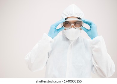 Portrait Asian Doctor In Protective PPE Suit Wearing Face Mask And Eyeglasses For Protect Coronavirus Covid-19 Virus.Scientist Male Wearing Personal Protection Equipment Making Laboratory In Hospital.