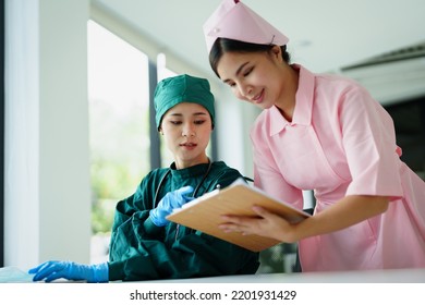 Portrait Of Asian Doctors And Nurses Using Computers And Documents To View Patient Information To Analyze Symptoms Before Treatment