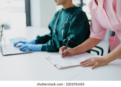 Portrait Of Asian Doctors And Nurses Using Computers And Documents To View Patient Information To Analyze Symptoms Before Treatment