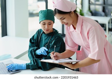 Portrait Of Asian Doctors And Nurses Using Computers And Documents To View Patient Information To Analyze Symptoms Before Treatment