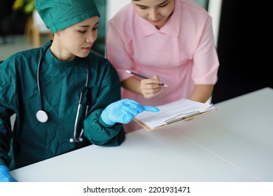 Portrait Of Asian Doctors And Nurses Using Computers And Documents To View Patient Information To Analyze Symptoms Before Treatment