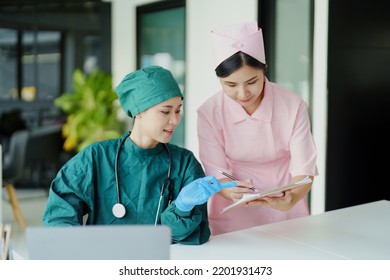 Portrait Of Asian Doctors And Nurses Using Computers And Documents To View Patient Information To Analyze Symptoms Before Treatment