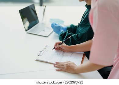 Portrait Of Asian Doctors And Nurses Using Computers And Documents To View Patient Information To Analyze Symptoms Before Treatment