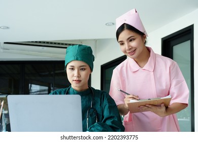 Portrait Of Asian Doctors And Nurses Using Computers And Documents To View Patient Information To Analyze Symptoms Before Treatment