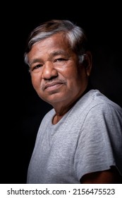 Portrait Of Asian Elderly Man Alone Looking At Camera In Studio On Dark Background, Wrinkled Skin, Gray Hair, 60+ Years Old.