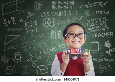 Portrait of asian elementary school student showing LEARN word in class