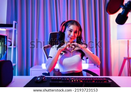 Portrait of Asian esport woman gamer play online video game on computer. Attractive young girl gaming player feel happy enjoy technology broadcast live streaming while plays cyber tournament at home.