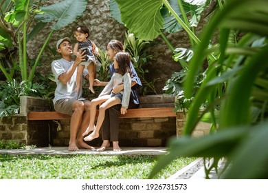 Portrait Of Asian Family Enjoy Their Time At Tropical Backyard At Home