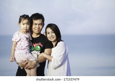 Portrait Of Asian Family Walking On The Beach