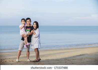 Portrait Of Asian Family Walking On The Beach