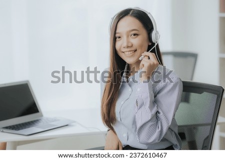 Portrait of Asian female call center operator with headset working support hotline in modern office Smiling Asian woman talking to customer service through headset
