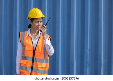Portrait of Asian Female Container Worker  Using Walkie Talkie Radio Communication to Communicate with His Friend