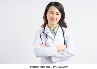 Portrait of Asian female doctor holding hands and smiling
