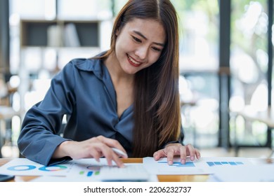 Portrait Of An Asian Female Employee Using A Calculator To Calculate Corporate Income Tax To Submit Evidence To The Revenue Department Before The End Of The Year.