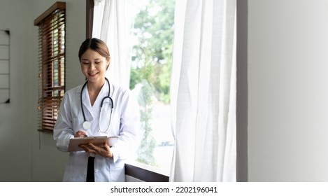 Portrait Asian Female Medical Doctor Taking Note On Clipboard.