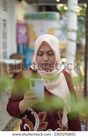 Portrait of Asian female model holding mobile phone